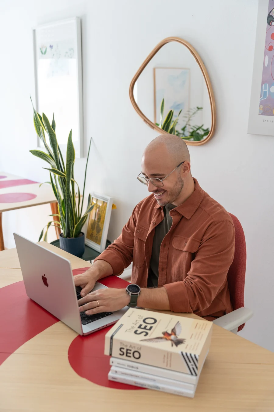 Francesco Nocentini, SEO Specialist, al lavoro al computer con i libri 'The Art of SEO' sulla scrivania